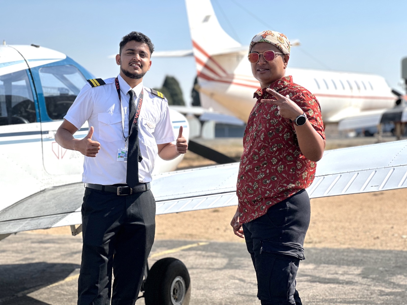 Adam Harry standing beside filmmaker Neelu Bhuman in front of an aircraft